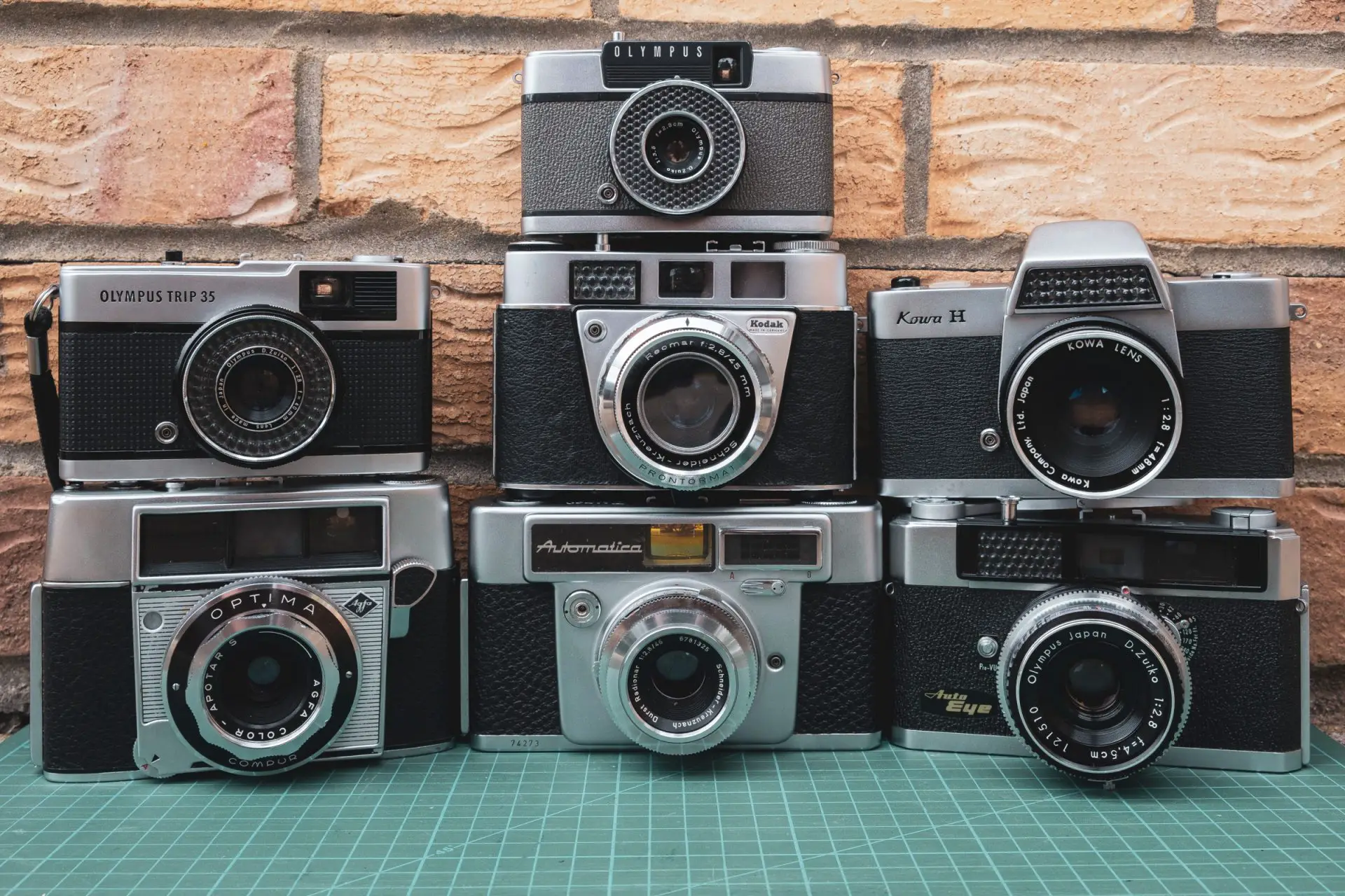 Eight film cameras stacked in three rows